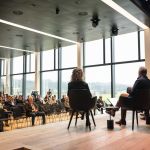 Blick auf Podiumsdiskusstion mit Puplikum