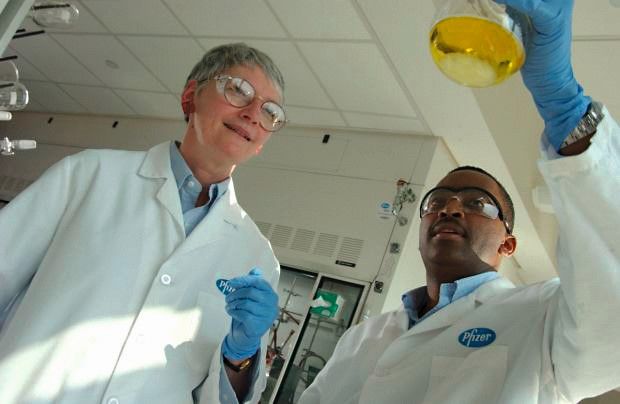 Zwei Menschen im Labor mit Reagenz Glas