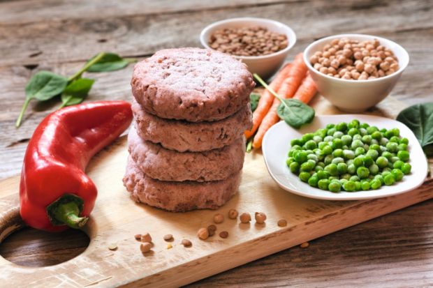 Burgerpatties und Gemüse auf Holzbrettchen
